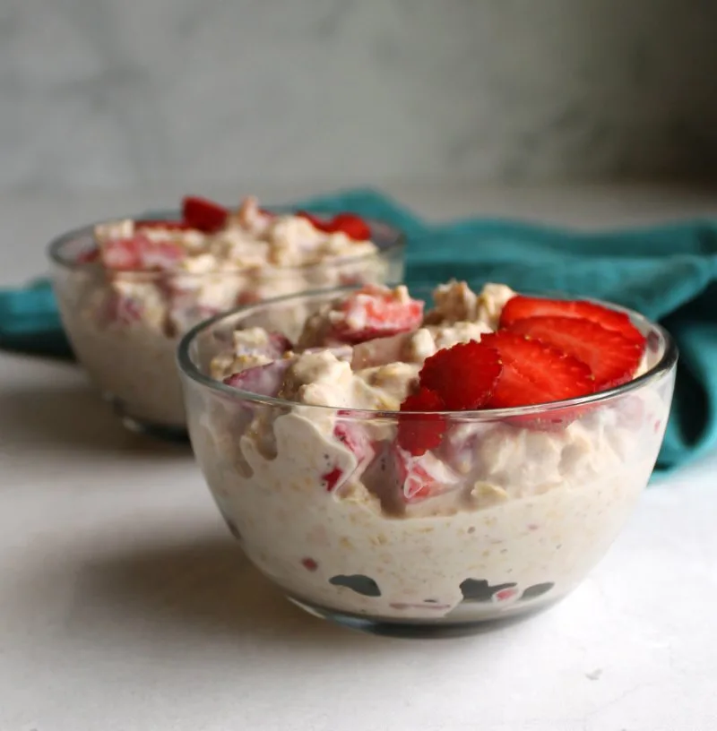 looking across two glass bowls of creamy strawberry overnight oatmeal.