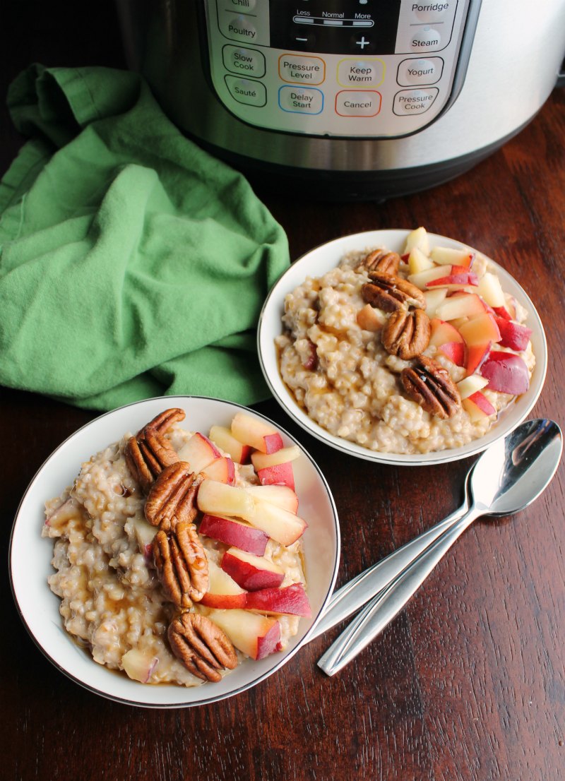 Bowls of maple cinnamon steel cut oatmeal with peaches and pecans in front of pressure cooker.