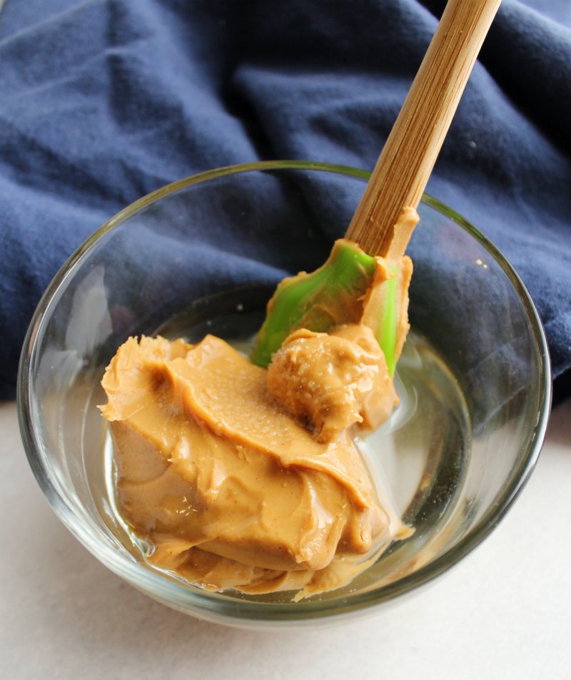 small glass bowl with peanut butter and melted coconut oil