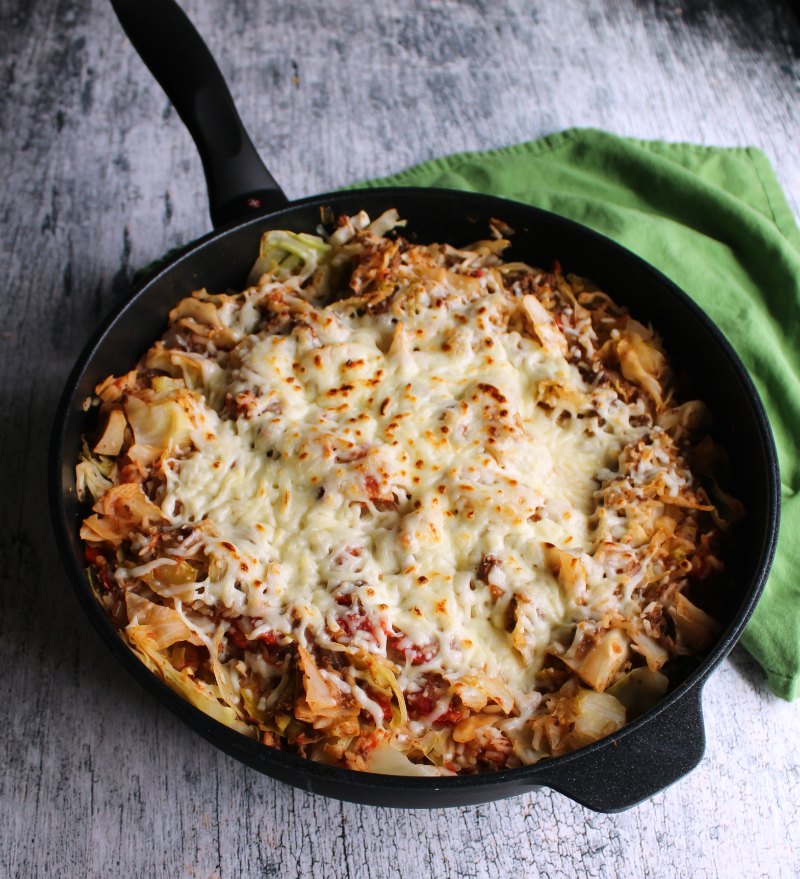 skillet of un-stuffed cabbage roll skillet meal with browned mozzarella cheese on top.