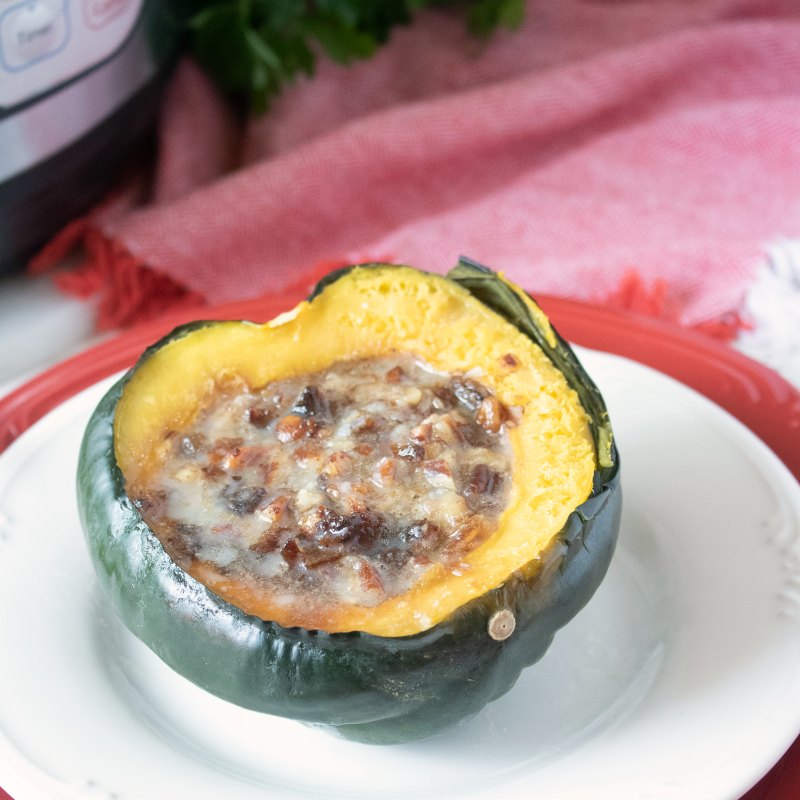 close up of acorn squash half stuffed with dates pecans and brown sugar
