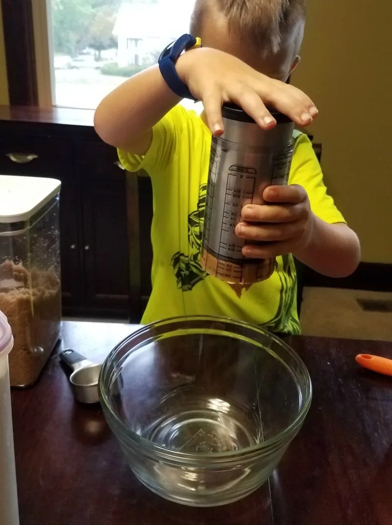 putting peanut butter in bowl for chocolate peanut butter playdoh.