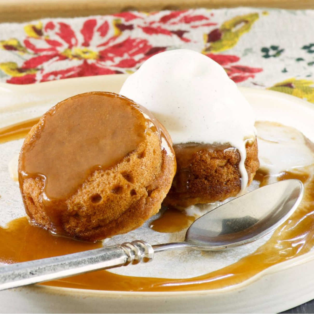 Two mini sweet potato cakes served with caramel sauce and a scoop of vanilla ice cream.