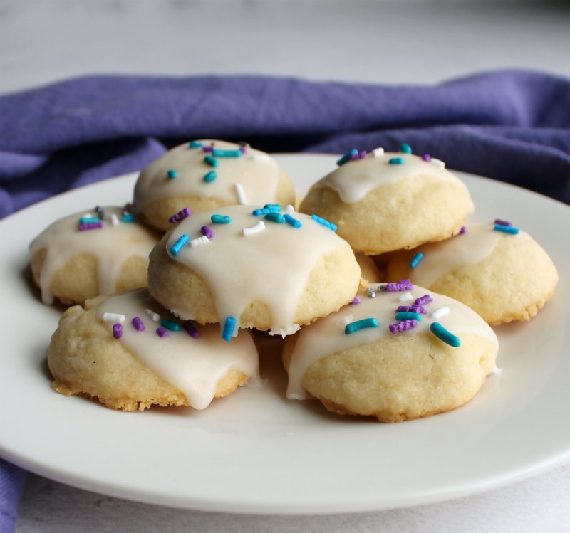 looking across a plate of melting moments cookies with buttery texture and powdered sugar glaze showing