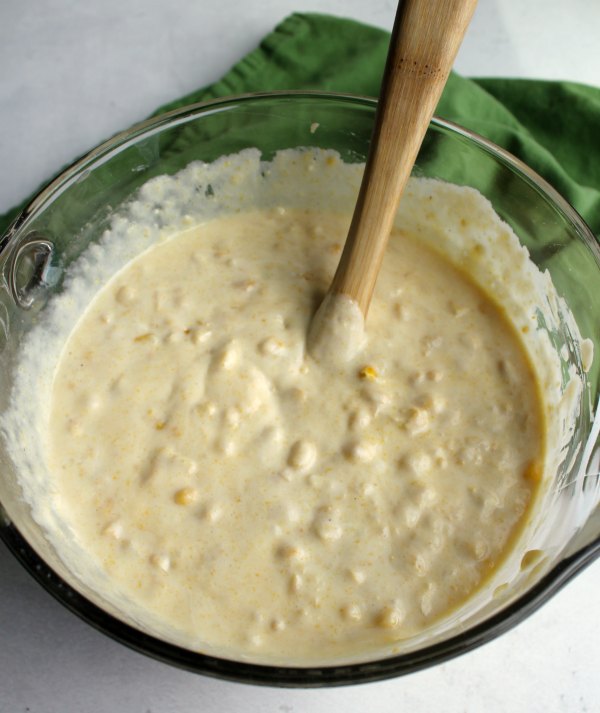 glass mixing bowl full of corn casserole batter