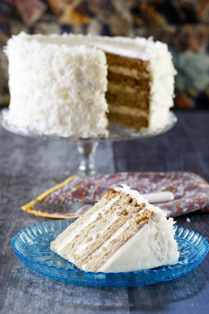 layered banana cake on stand with slice of cake served in front of it