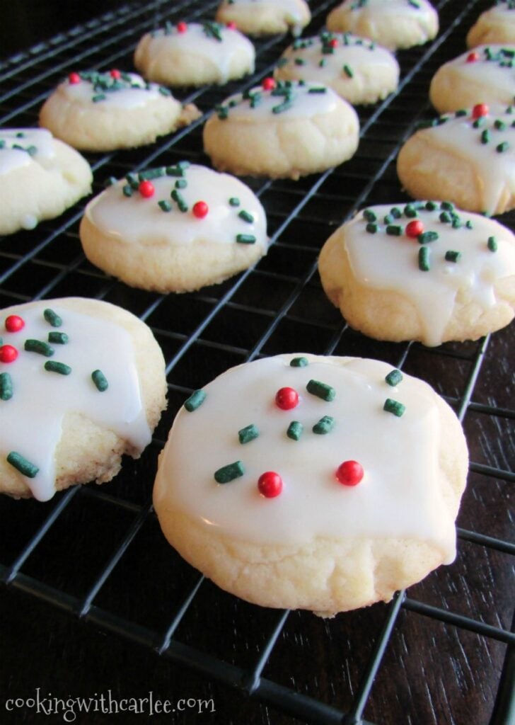Melting Moments Cookies 9 Tender melt in your mouth melting moments cookies with glaze and Christmas sprinkles on wire cooling rack.