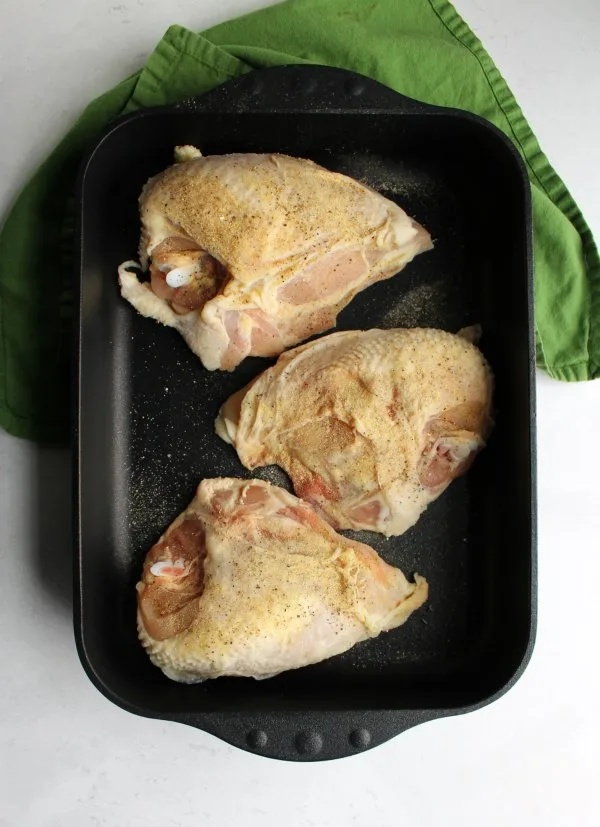 seasoned split chicken breasts in swiss diamond roasting pan ready to go in oven.