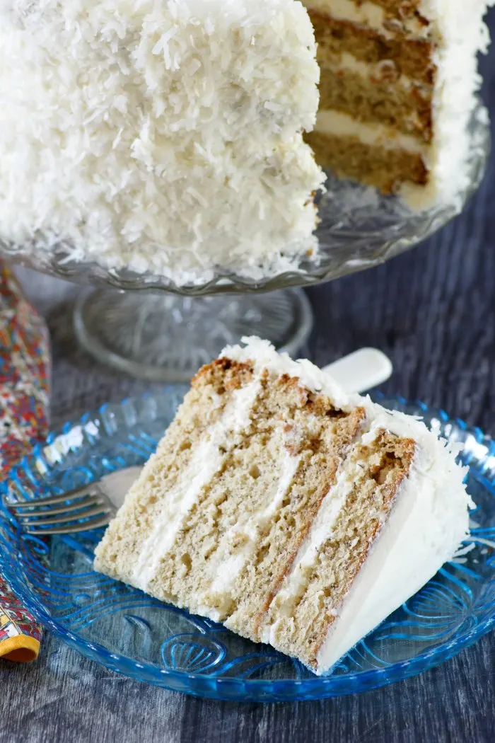 banana cake with 4 layers of cake, fluffy white meringue frosting and bright white coconut
