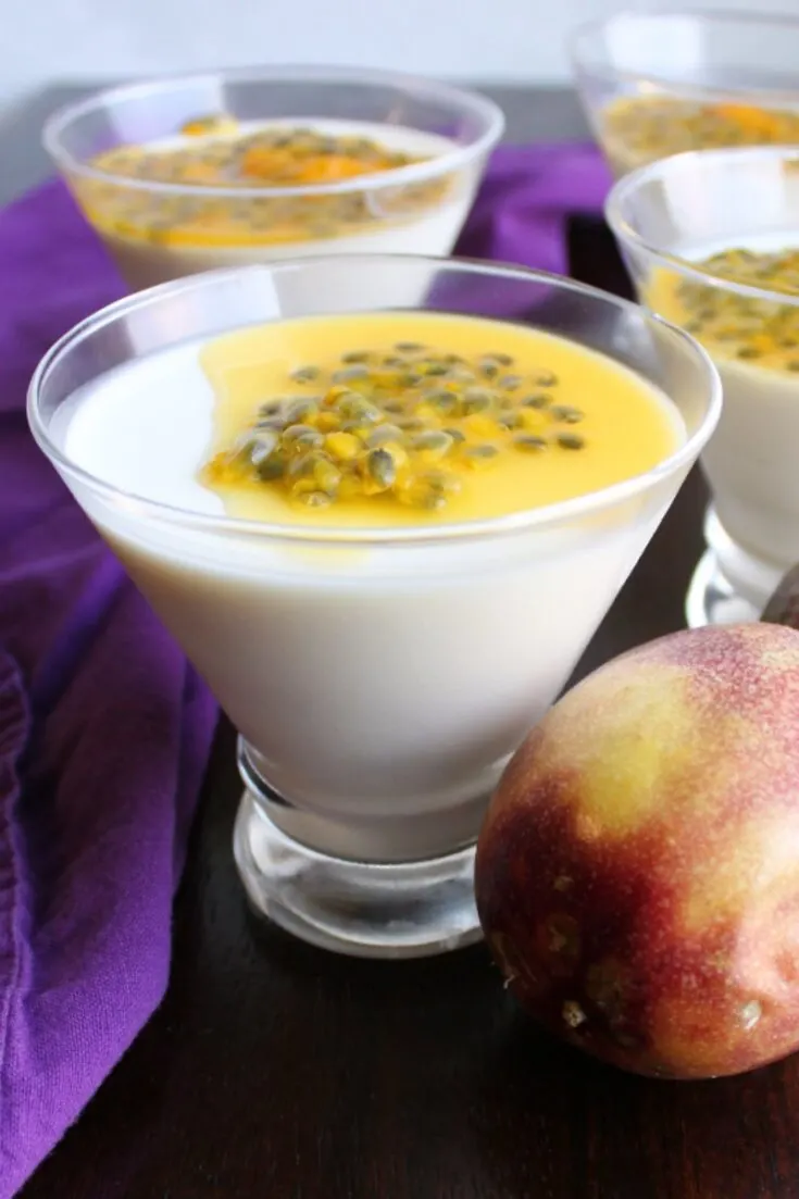 martini glasses filled with creamy white panna cotta and topped with yellow passion fruit.