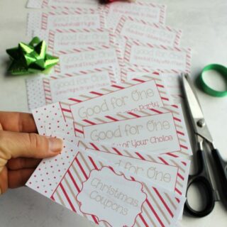 cutting out free printable pages to make a kid's coupon book for Christmas.