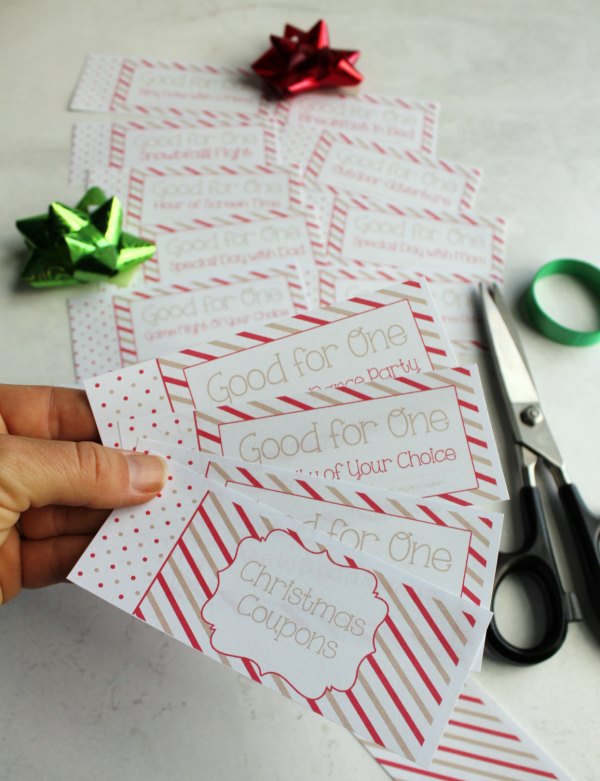 cutting out free printable pages to make a kid's coupon book for Christmas.