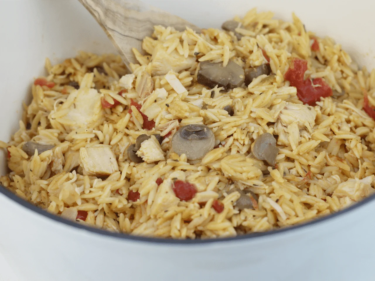 Dutch oven filled with orzo with chicken and vegetables. 