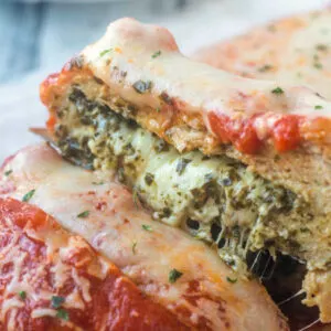 Showing melted cheese and pesto inside marinara and cheese topped chicken meatloaf.