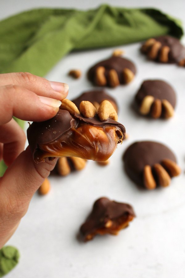 hand holding bear paw candy with soft caramel center showing.