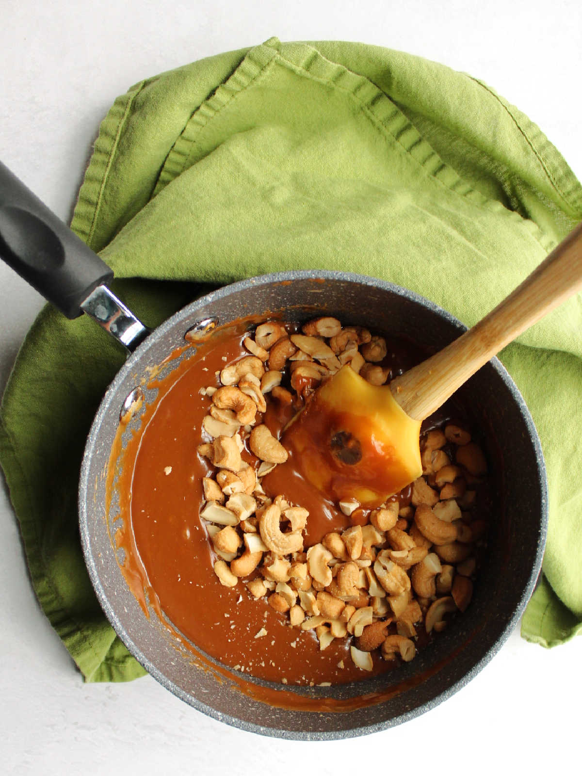 saucepan filled with melted caramel and cashew pieces.