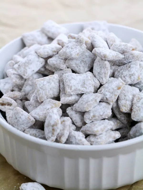 bowl of powdered sugar covered caramel puppy chow.