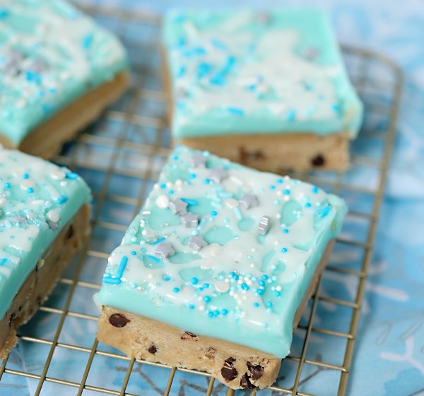 no bake peanut butter cookie dough bars with blue frosting and sprinkles.
