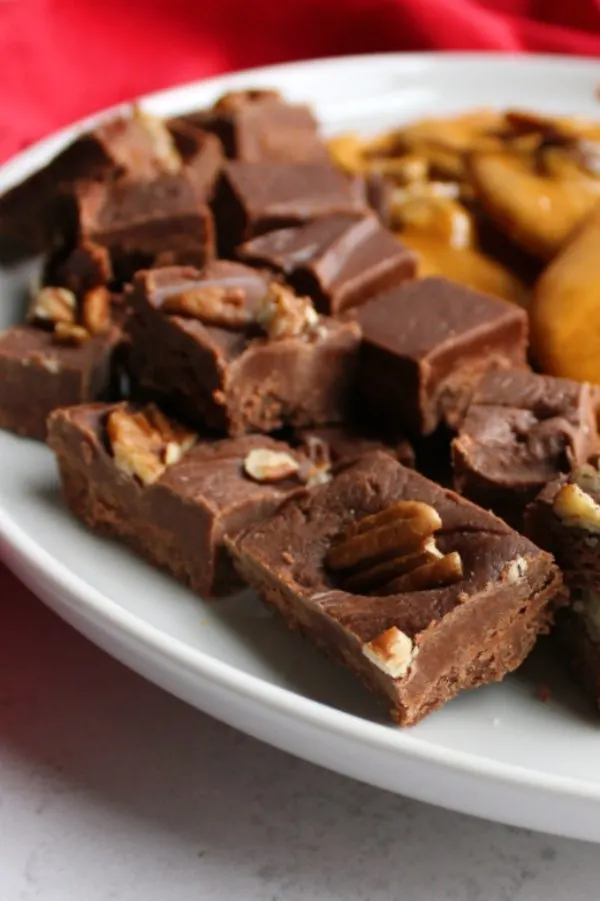 squares of fudge on plate with pecan brittle.