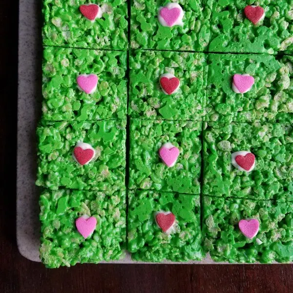 green rice krispie treats with red and pink hearts in the middle for Grinch treats.