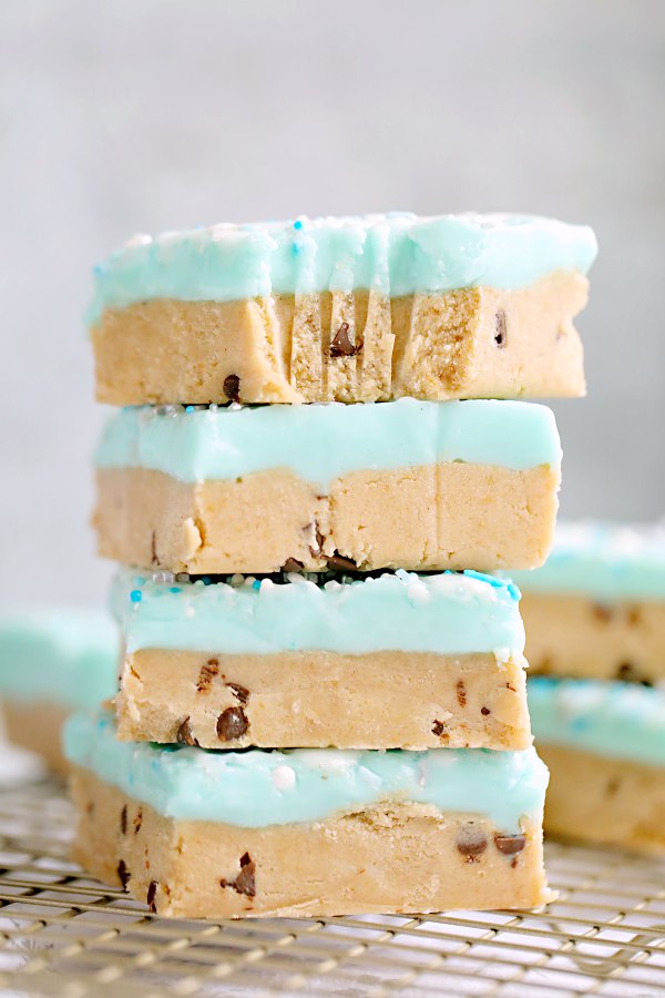 stack of peanut butter cookie bars with blue icing and sprinkles.