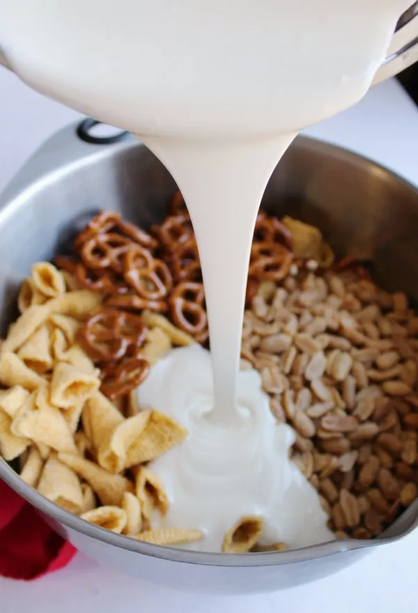pouring melted white chocolate over pretzels, peanuts, bugles etc. 