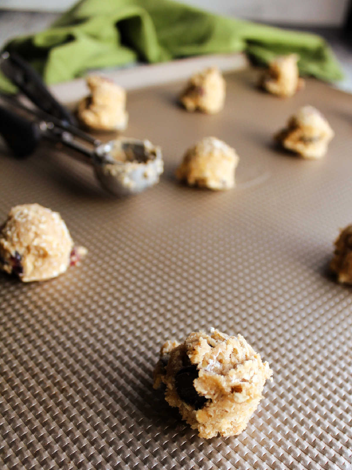 small scoops of oatmeal raisin cookie dough on cookie sheet, ready to bake. 