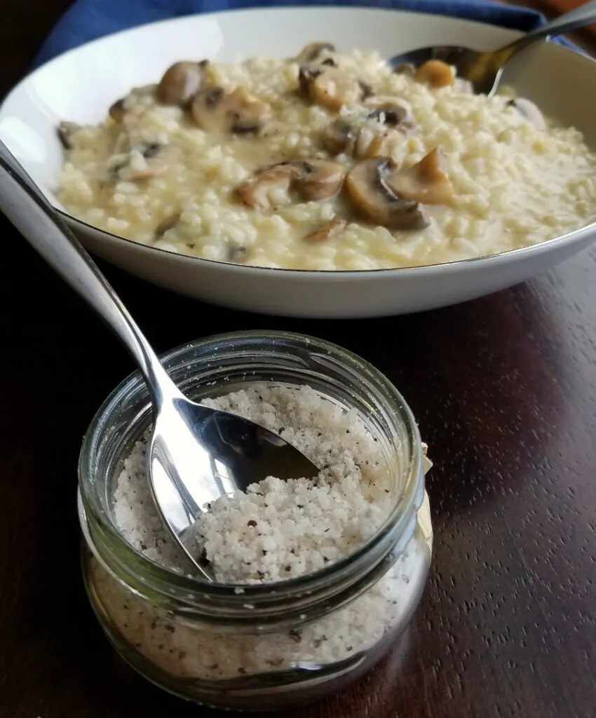 bowl of mushroom risotto with container of truffle salt