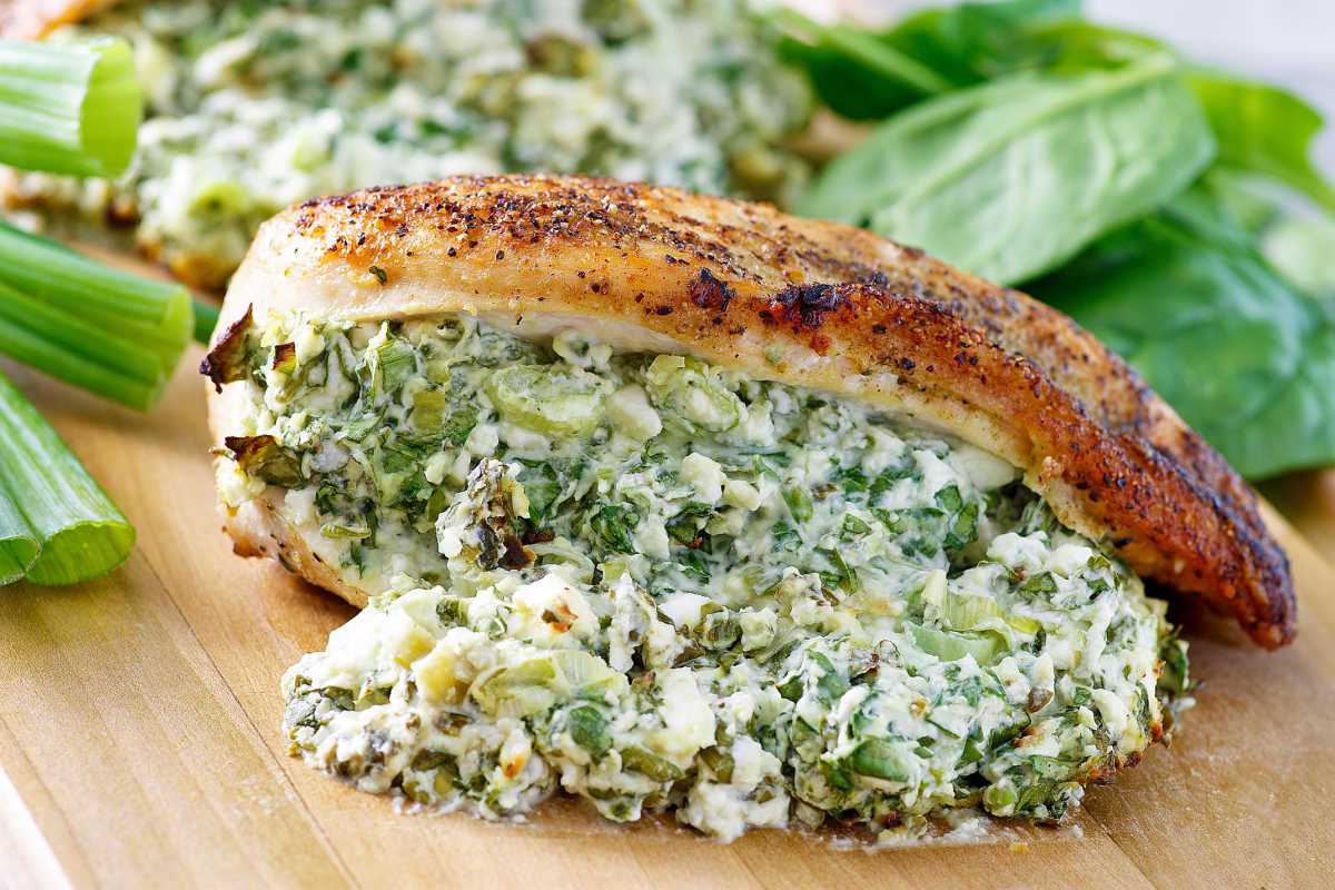 close up of a chicken breast stuffed with creamy feta, spinach and green onion filling.