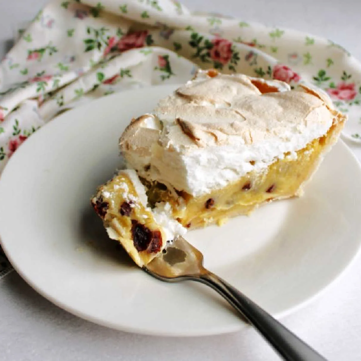 bite of sour cream raisin pie topped with a layer of fluffy meringue on fork.
