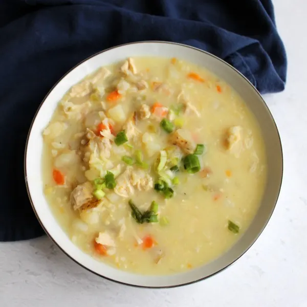 bowl of lemony chicken soup with rice, potatoes, carrots, celery and onions and egg thickened broth avgelemono.