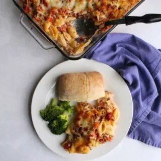 dinner plate filled with creamy ground beef and noodle casserole, broccoli and bread.
