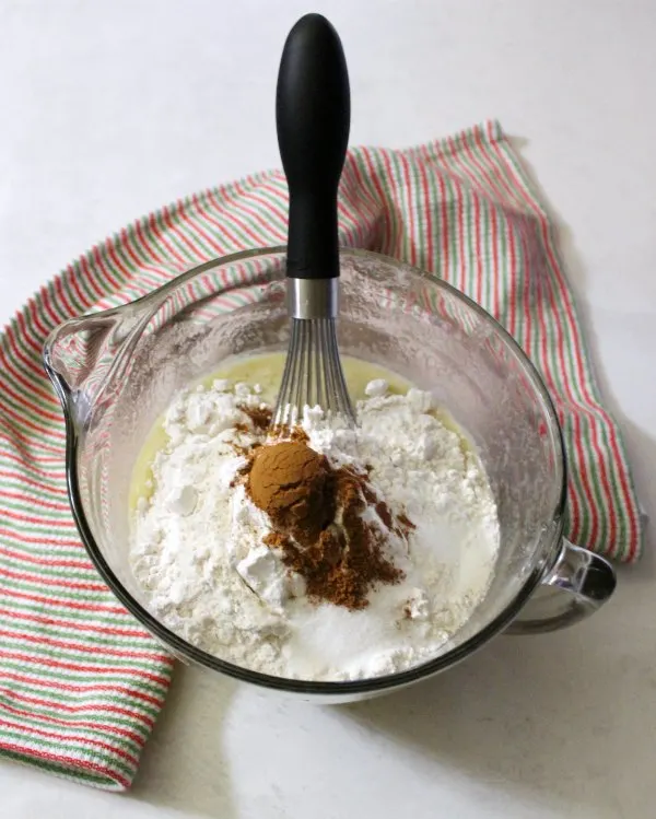 Banana bread ingredients in bowl with whisk.