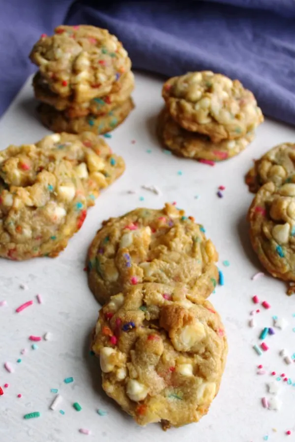 stacks and piles of funfetti cookies with sprinkles around them