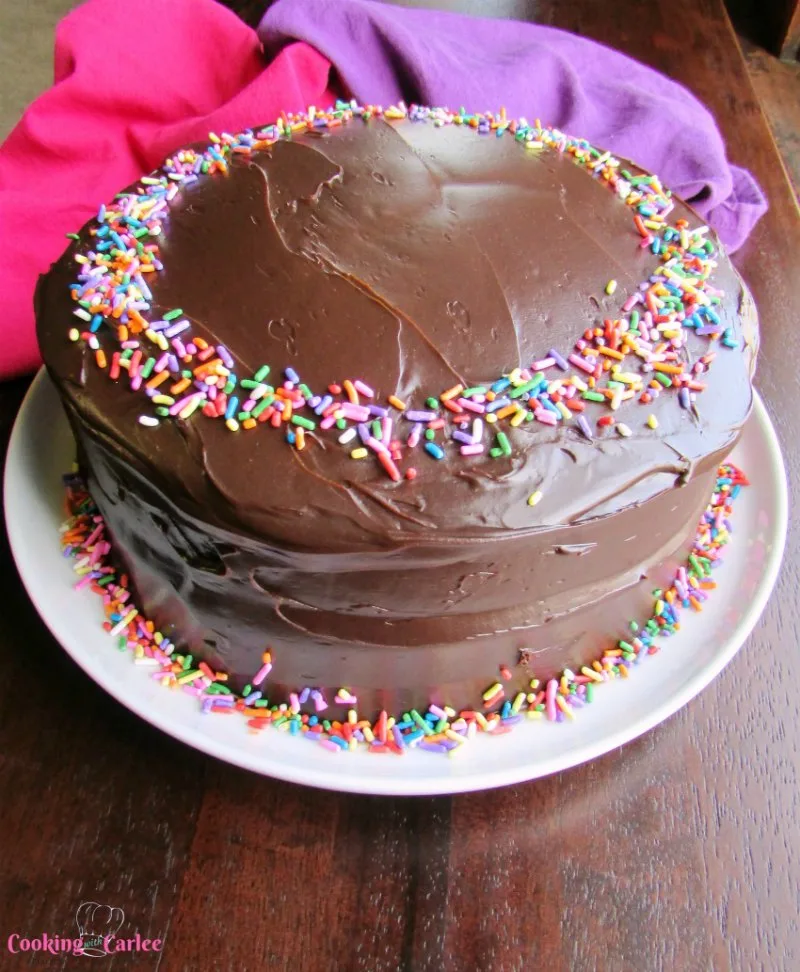 devilishly good chocolate cake with shiny fudge frosting and sprinkles
