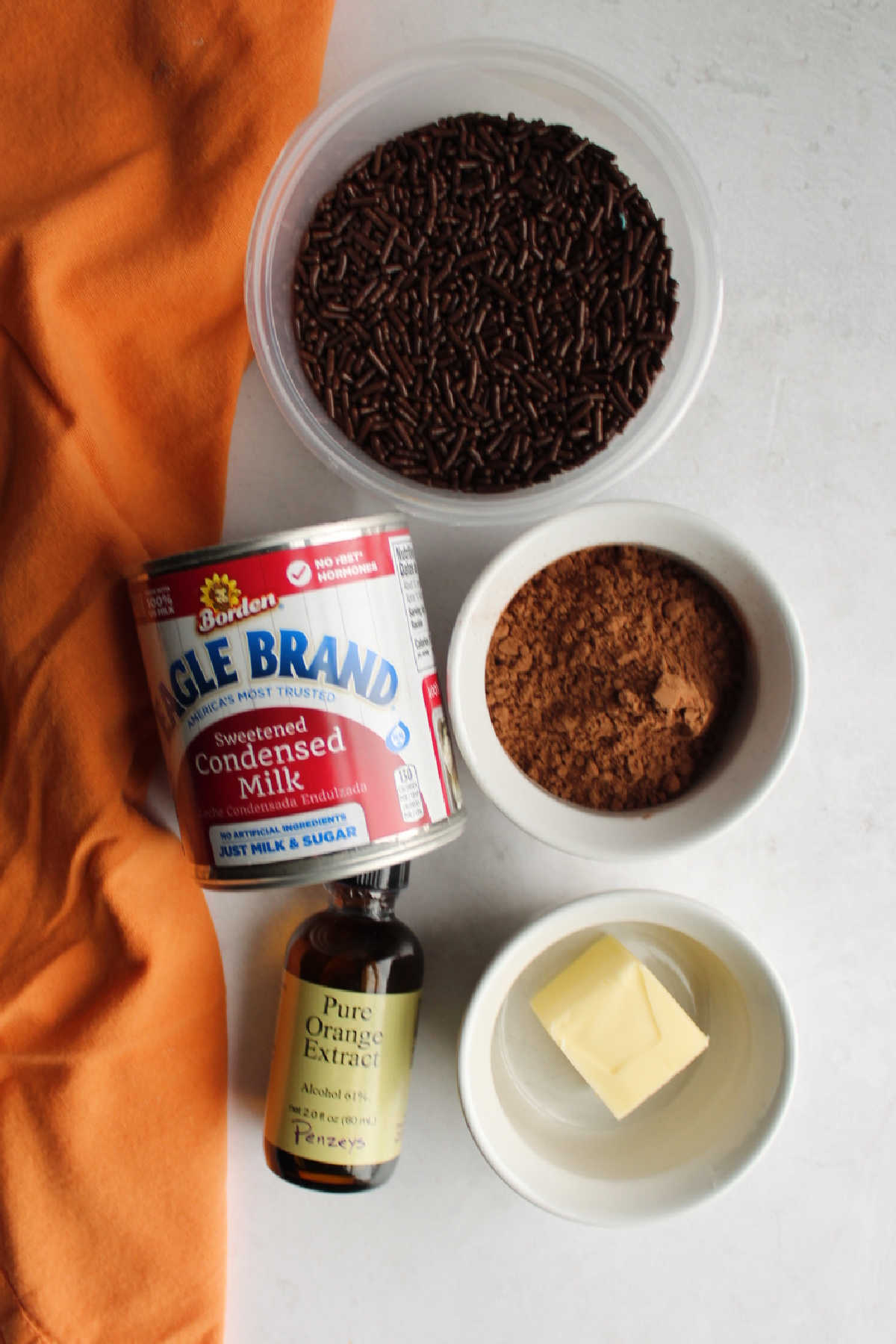 Ingredients: condensed milk, cocoa powder, butter, orange extract and chocolate sprinkles ready to be made into brigadeiros. 