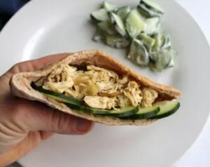 pita filled with shredded chicken mixture and cucumber slices.