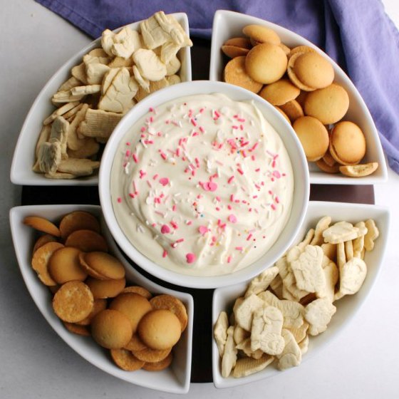 bowl of lemon cheesecake dip with vanilla wafer and animal cracker dippers.
