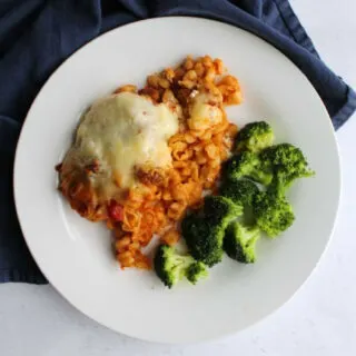 dinner plate with baked Italian style pasta casserole and broccoli.