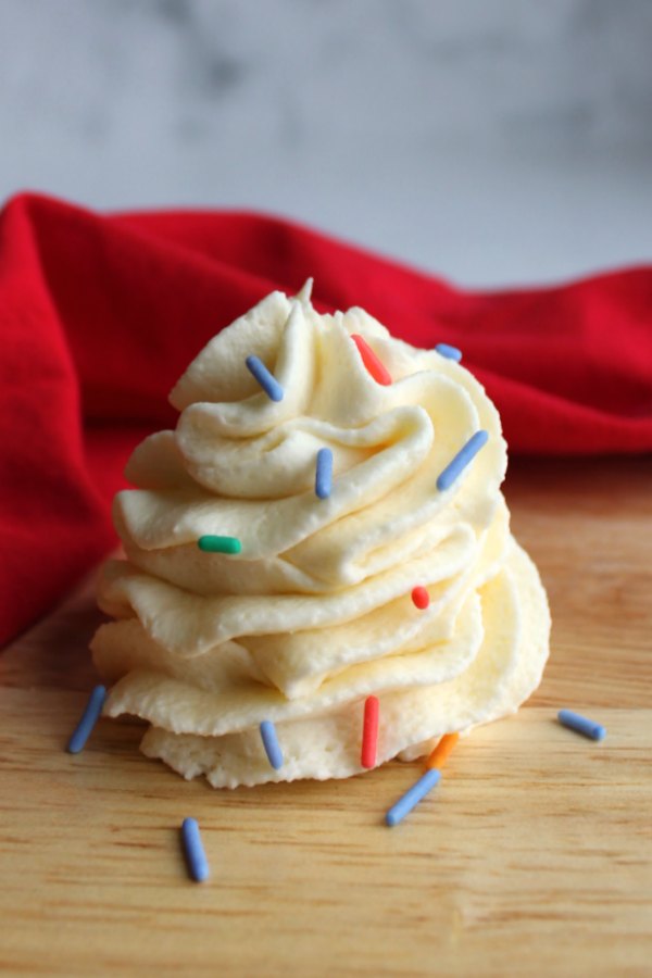 Swirl of creamy russian buttercream with colorful sprinkles.