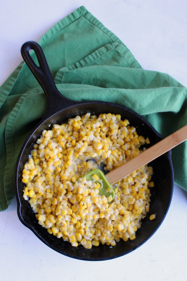 cast iron skillet filled with creamy corn mixture