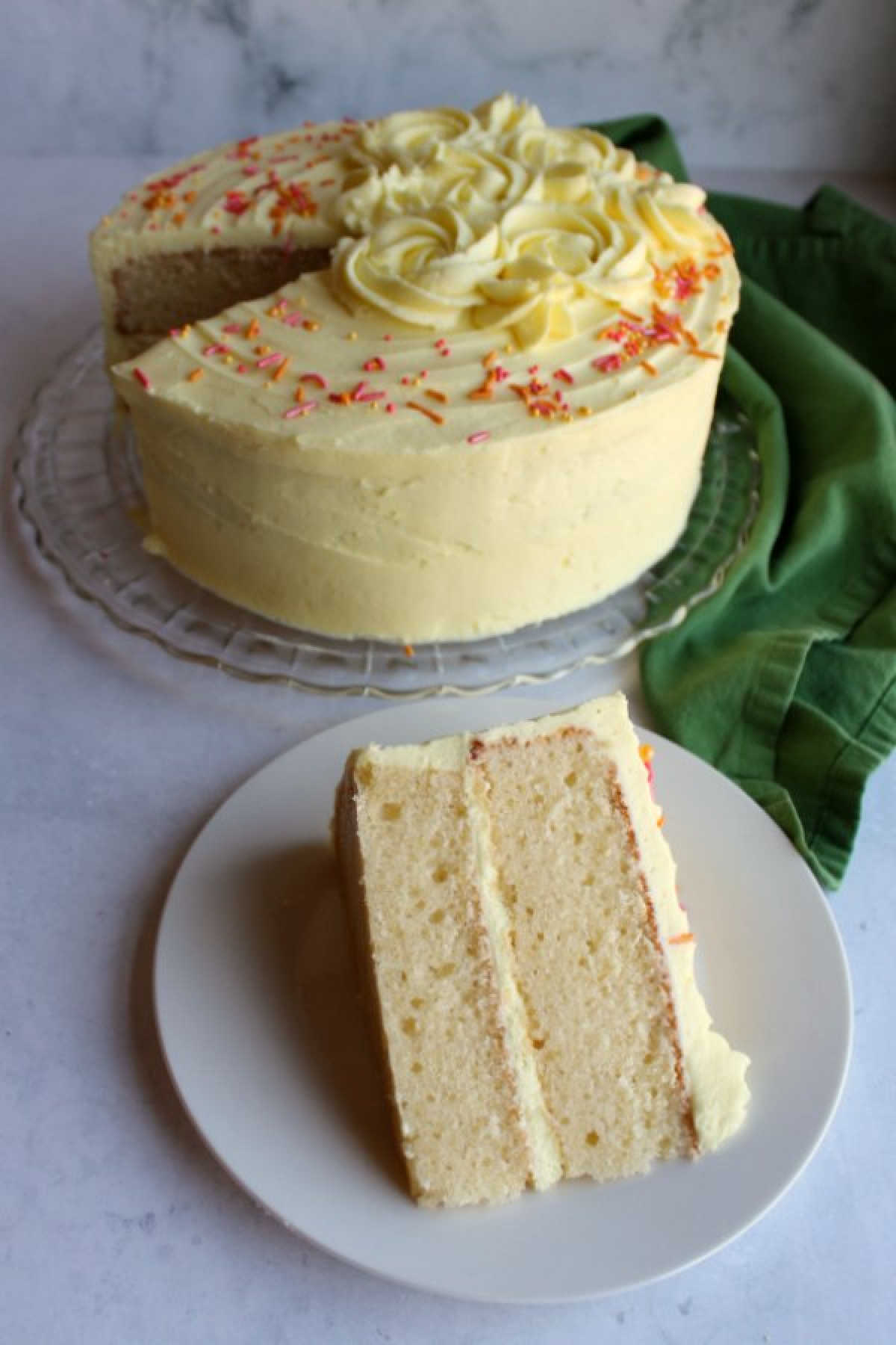 slice of lemon velvet cake lying down on dessert plate.
