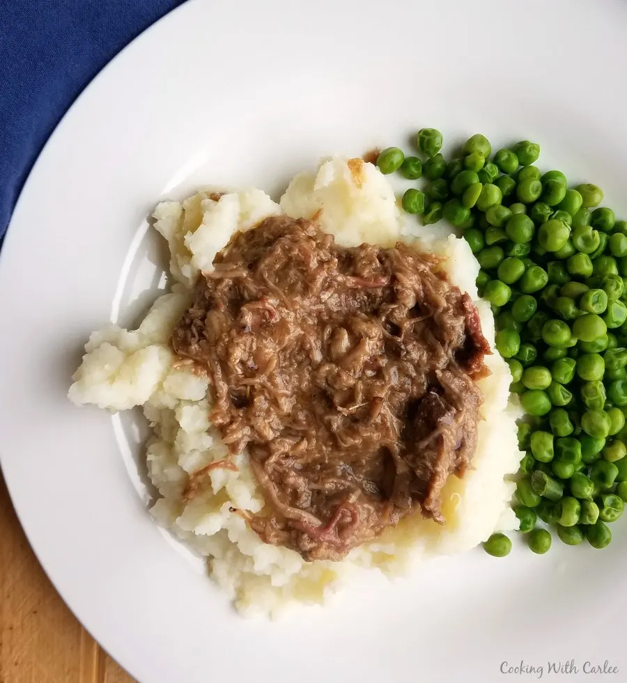 balsamic and rosemary braised pulled pork served over mashed potatoes with peas.
