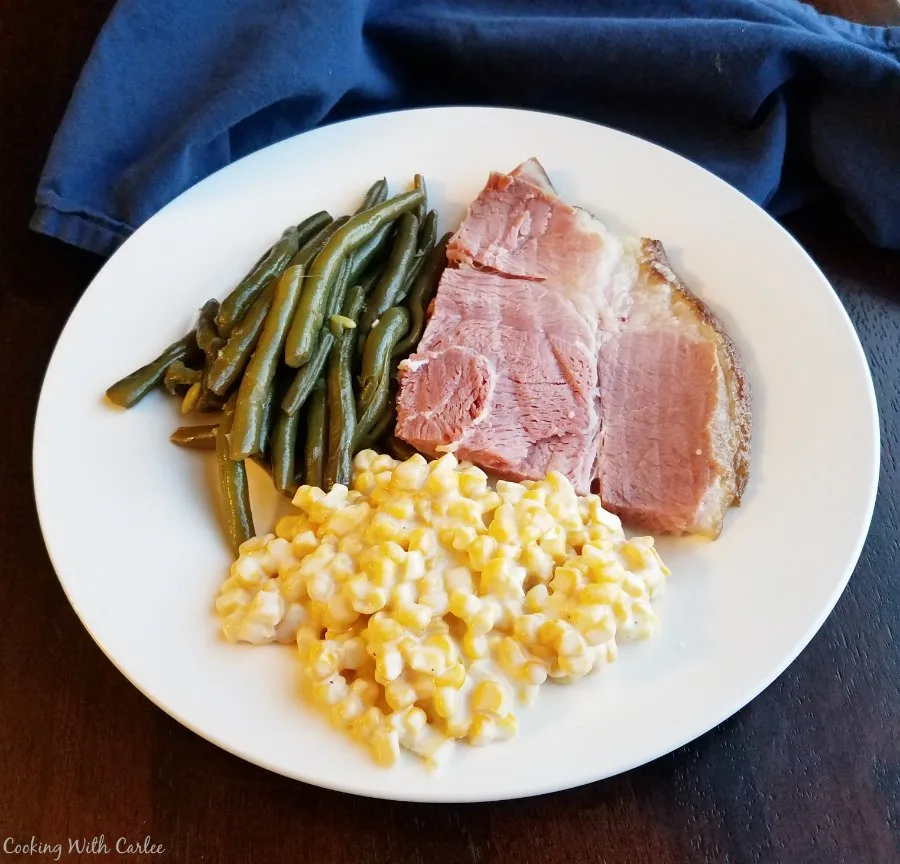 ham, green beans and creamy corn on dinner plate.