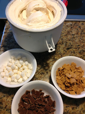 freshly churned ice cream next to bowls of marshmallows, grahams and chocolate