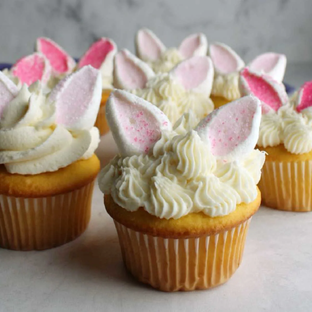 close up of group of bunny cupcakes with piped buttercream and marshmallow ears.