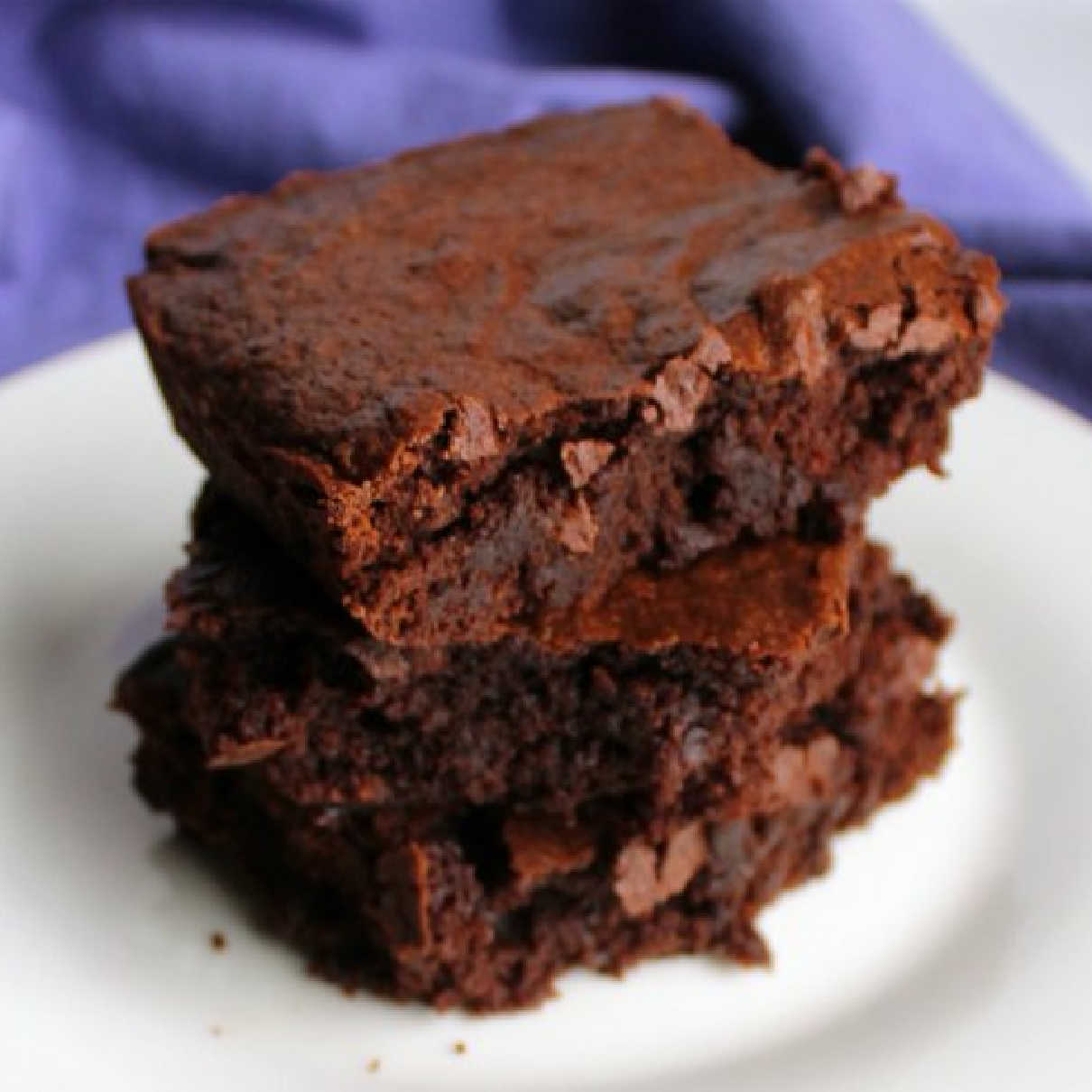 Pieces of rich brownies stacked on top of each other, ready to eat.