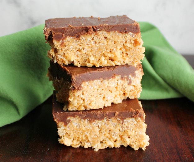 stack of maple peanut butter rice krispie treats with fudge frosting on top.