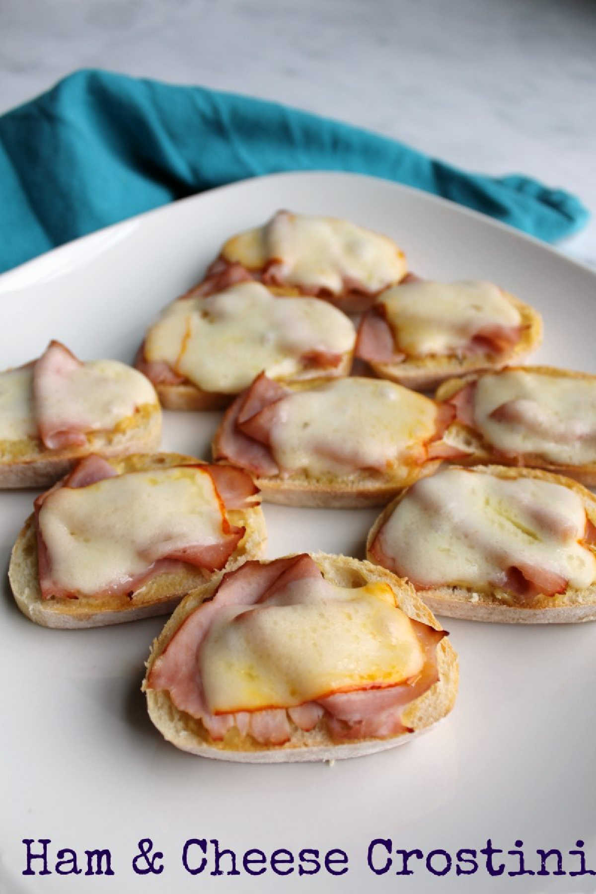 Ham and cheese crostini are the perfect appetizer no matter the occasion. Sliced baguette with mustard, ham and melted cheese come together for a simple but delicious finger food. We like them so much, we often make a meal of them!