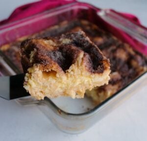 lifting piece of sopapilla cheesecake out of square pan.